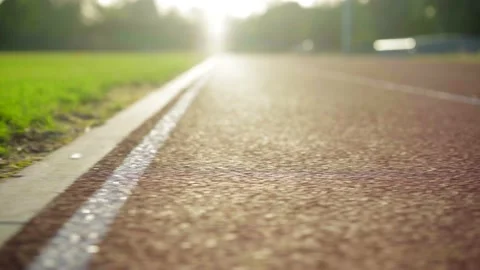 Beautiful sun rays landing on a sprint track edge in an empty olympic Stock Footage