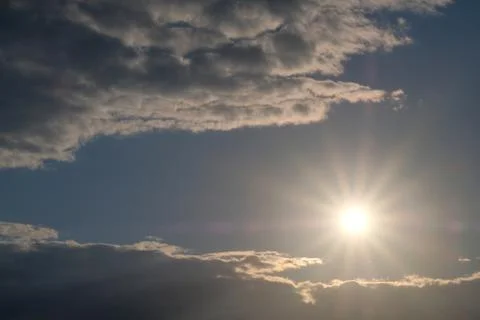 Beautiful sun with rays of light on a background of clouds. Evening or morning Stock Photos