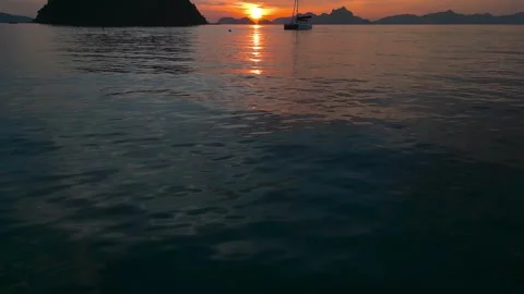 Beautiful sun rays on sea at sunset with moutains in the background Vídeos de archivo 253781605