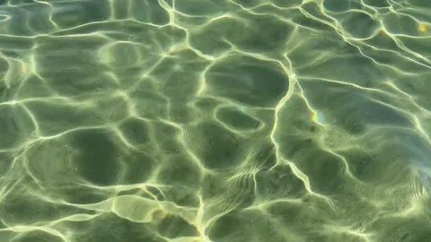Beautiful sun reflection and light caustics on a sandy bottom through cryst.. Stock Footage 336976480