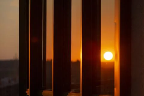 Beautiful sun at sunset is reflected in the windows Stock Photos