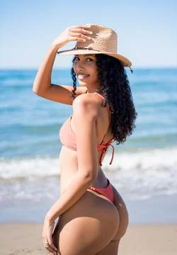 A Beautiful SunKissed Model Posing in Stylish Bikinis Amidst the Warm Sand at Stock Photos