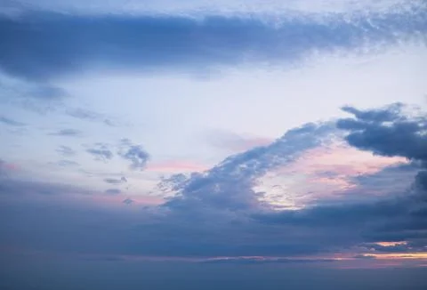 A beautiful sunrise sky with a gradient from deep blue to soft pink and gold Stock Photos