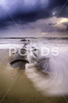 Beautiful sunrise sunset at the beach. dramatic clouds. soft focus on the wav Stock Photos