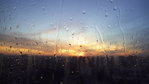 Beautiful sunrise while raining. Watching the sunrise behind the window. 4K Stock Footage 83504952