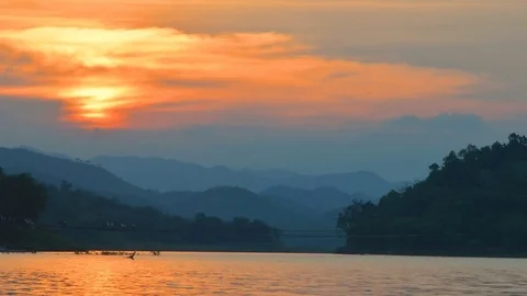 Beautiful sunset and dramatic sky over the lake with mountain range as backgroun 库存影片 83965332