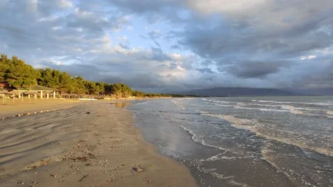 Beautiful sunset at a beach with the waves flowing Video stock 169883144