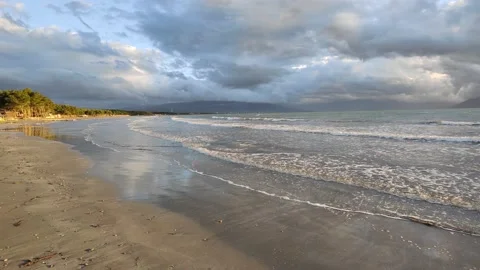 Beautiful sunset at a beach with the waves flowing Video stock 169883233