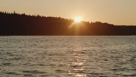 Beautiful sunset on a calm ocean with a forest on the island. Stock Footage 249209784