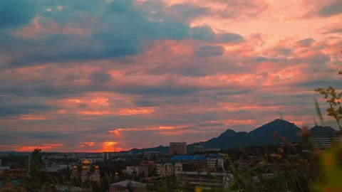 A beautiful sunset casts warm hues over the city and mountains, with vibrant Stockbeeldmateriaal 312149087