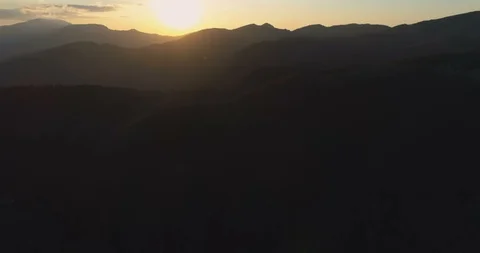 Beautiful sunset with clear light blue sky over dark mountain silhouettes Stock Footage 129225058