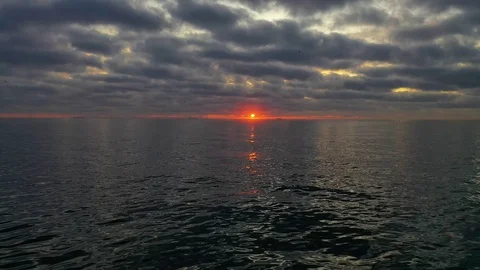 Beautiful sunset with clouds aerial drone shot over the ocean in 4k Stock Footage 119548595