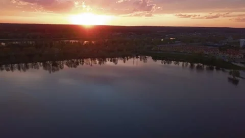 Beautiful sunset with clouds over the river under construction houses in the Vídeos de archivo 155783664