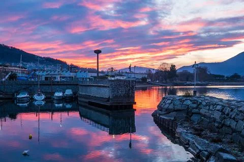 Beautiful sunset with colored clouds and boats that are reflected in the wa.. Foto stock