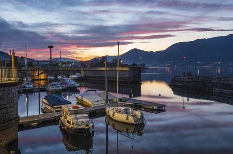 Beautiful sunset with colored clouds and boats that are reflected in the wa.. Stock Photos