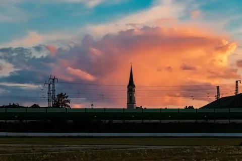 Beautiful sunset with dramatic clouds behind a church at Plattling, Isar, ... Stock Photos