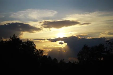 Beautiful Sunset With Dramatic Clouds Over a Forested Landscape Stock Photos