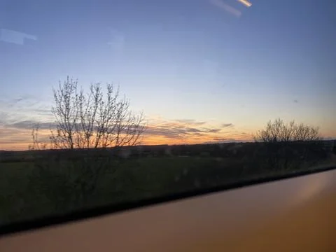 Beautiful sunset in the fields seen from a train window Stock Photos