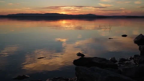 Beautiful sunset on the lake. Mirror reflection of the sky on the water. Video stock 250233823