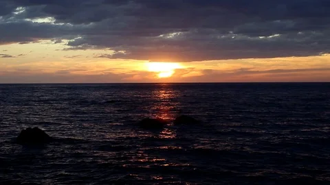 Beautiful sunset with low gray clouds over the sea Stock Footage 122202370