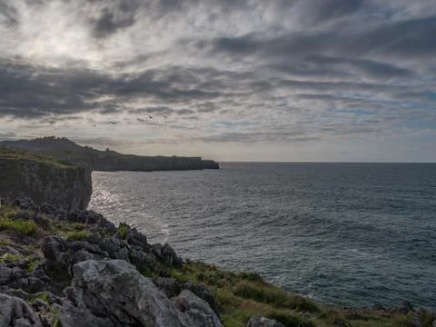Beautiful sunset next to some cliffs by the sea Stock Photos