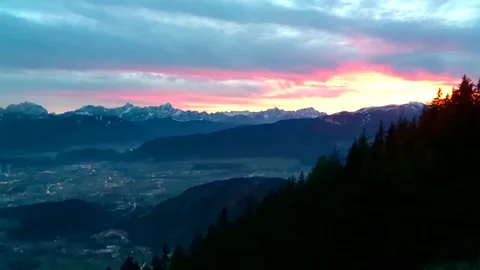 Beautiful sunset over austria mountains valley and dark forest Stock Footage 256432584