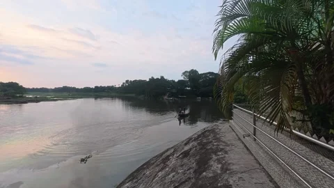 Beautiful sunset over calm river with brick kiln chimney in distance Stock Footage 342157551