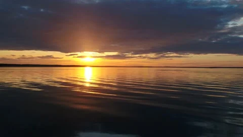 Beautiful sunset over lake with camera moving forward over the water Stock Footage 131425409