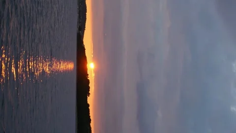 A beautiful sunset over a lake with a small boat in the water Stock Footage 274032301