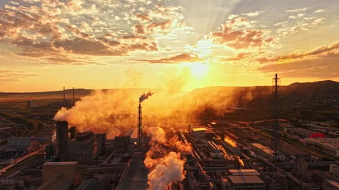 Beautiful sunset over a large industrial area with smoke rising from various Stock Footage 340879991