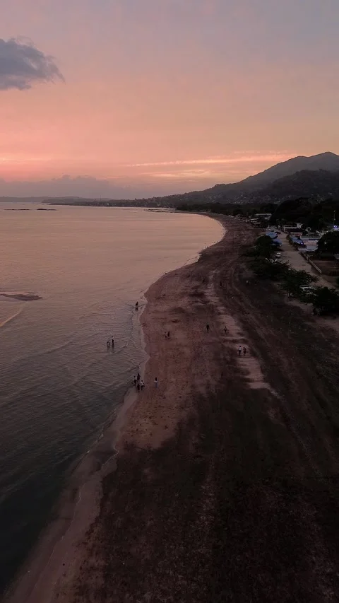 A beautiful sunset over the ocean with a beach in the background Stock Footage 326825413