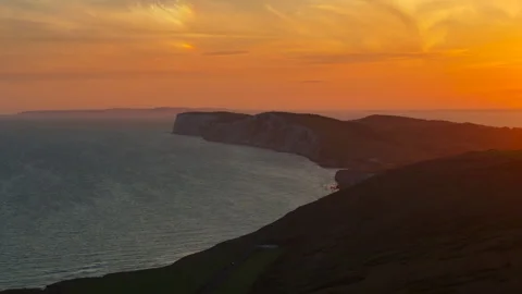 A beautiful sunset over the ocean with a cliff in the background Stock Footage 298249952