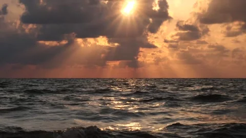 Beautiful sunset over the ocean with dramatic clouds and golden rays Stockbeeldmateriaal 284475964