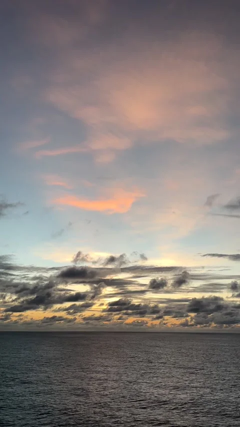 Beautiful sunset over ocean waves with colorful clouds in the evening sky Stock Footage 307883783