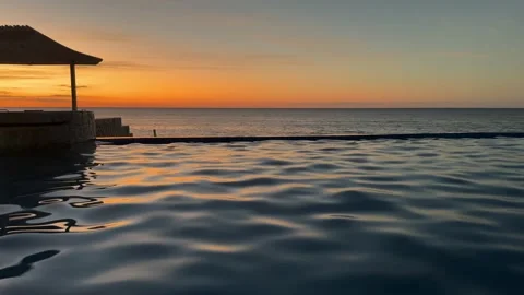 Beautiful sunset over rippling pool and ocean Stock Footage 330880576