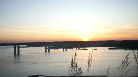 Beautiful sunset over the river and bridge with view from the car and the helm Stock Footage 82296816