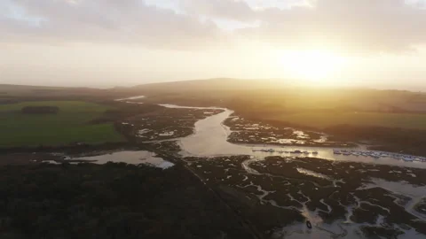 A beautiful sunset over a river with a few boats in the water Stock Footage 298288045