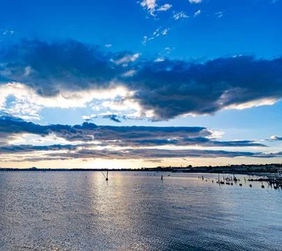 Beautiful Sunset Over Scenic Harbor with Vibrant Sky and Calm Sea Stock Photos
