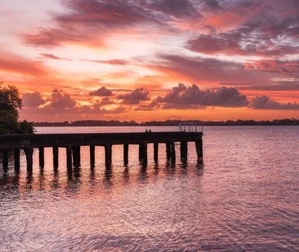 Beautiful Sunset Over Scenic Harbor with Vibrant Sky and Calm Sea Stock Photos