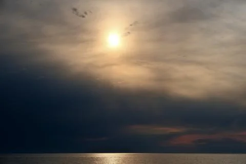 Beautiful Sunset Over the Sea with Dramatic Clouds and Sun Glitter on Water Stock Photos