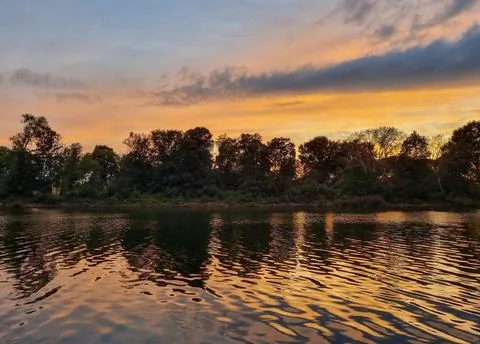 Beautiful Sunset Over Tranquil River Surrounded by Forests and Hills Stock Photos