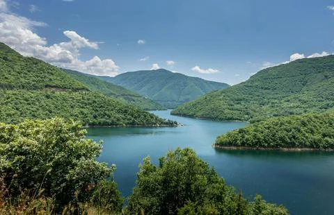 Beautiful Sunset Over Tranquil River Surrounded by Forests and Hills Stock Photos