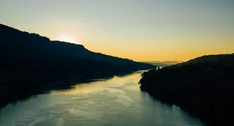 Beautiful Sunset Over Tranquil River Surrounded by Forests and Hills Stock Photos