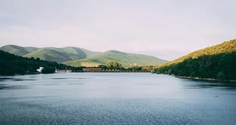 Beautiful Sunset Over Tranquil River Surrounded by Forests and Hills Stock Photos
