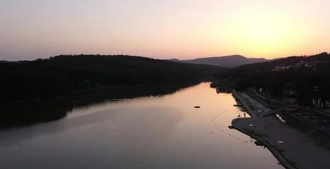 Beautiful Sunset Over Tranquil River Surrounded by Forests and Hills Stock Photos