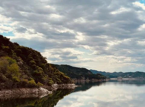 Beautiful Sunset Over Tranquil River Surrounded by Forests and Hills Stock Photos