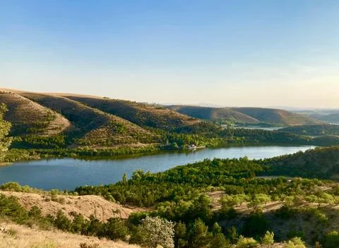 Beautiful Sunset Over Tranquil River Surrounded by Forests and Hills Stock Photos