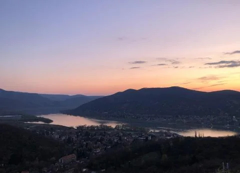 Beautiful Sunset Over Tranquil River Surrounded by Forests and Hills Stock Photos