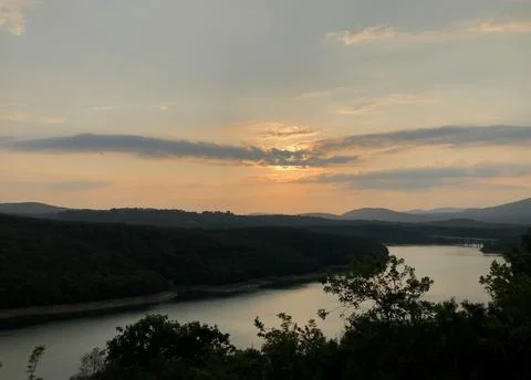 Beautiful Sunset Over Tranquil River Surrounded by Forests and Hills Stock Photos
