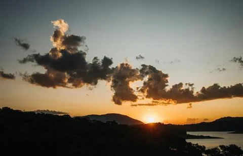 Beautiful Sunset Over Tranquil River Surrounded by Forests and Hills Stock Photos